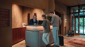 En receptionsdisk med en bardisk, ett träskåp och en skylt som visar rumens nummer och vilka bekvämligheter som finns.