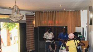 A lobby with a reception desk, a seating area with tufted sofas, and a chandelier. - Uranium Continental Hotel (Kaduna)