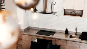 Una cocina moderna con encimera de granito, pileta de acero inoxidable y cocina por inducción negra.