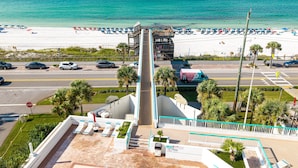 Un hotel frente a la playa con vista al océano, zona de piscina y aparcamiento.