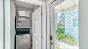 A compact laundry room with a washer, dryer, and microwave. - Nantucket Cottage 06ab 2 Bedroom Condo (Destin)