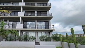 A multi-story residential building with balconies, large windows, and a flat roof. - Stunning Condo With Panoramic Ocean City Views (Cabo San Lucas)