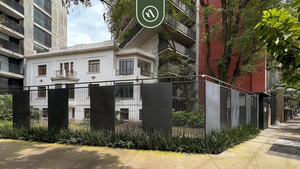 A modern building with a white facade, multiple balconies, and a gated entrance with a metal fence. - Stylish 1BR Apartment in Roma Norte Near Condesa (Mexico City)
