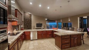 A spacious kitchen with granite countertops, stainless steel appliances, and a large island. - The Refuge (Fountain Hills)