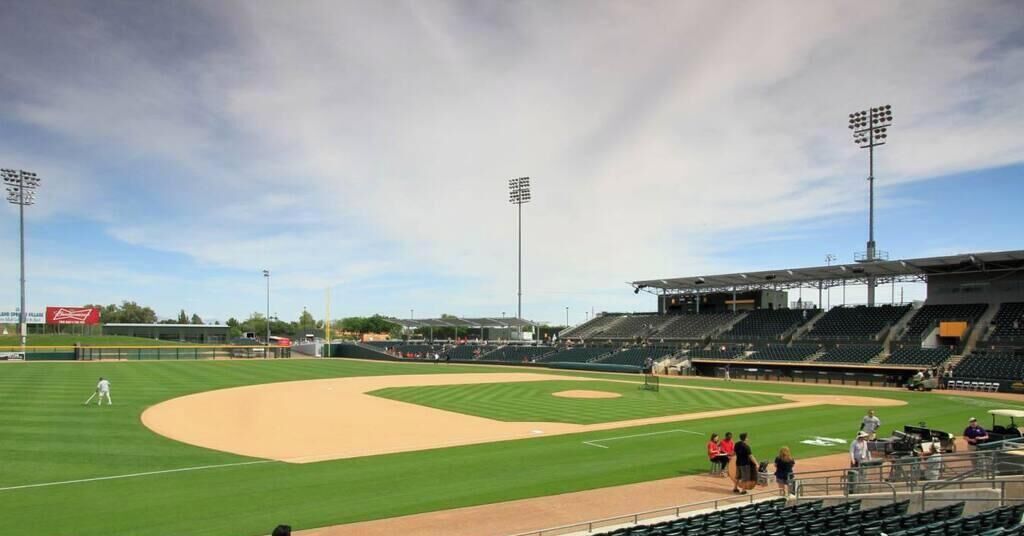 A baseball stadium with a large field, seating areas, and floodlights.