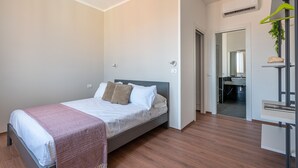 A modern bedroom with a bed, a bedside table, and a mirror. - Casa 73 by Wonderful Italy (Palermo)