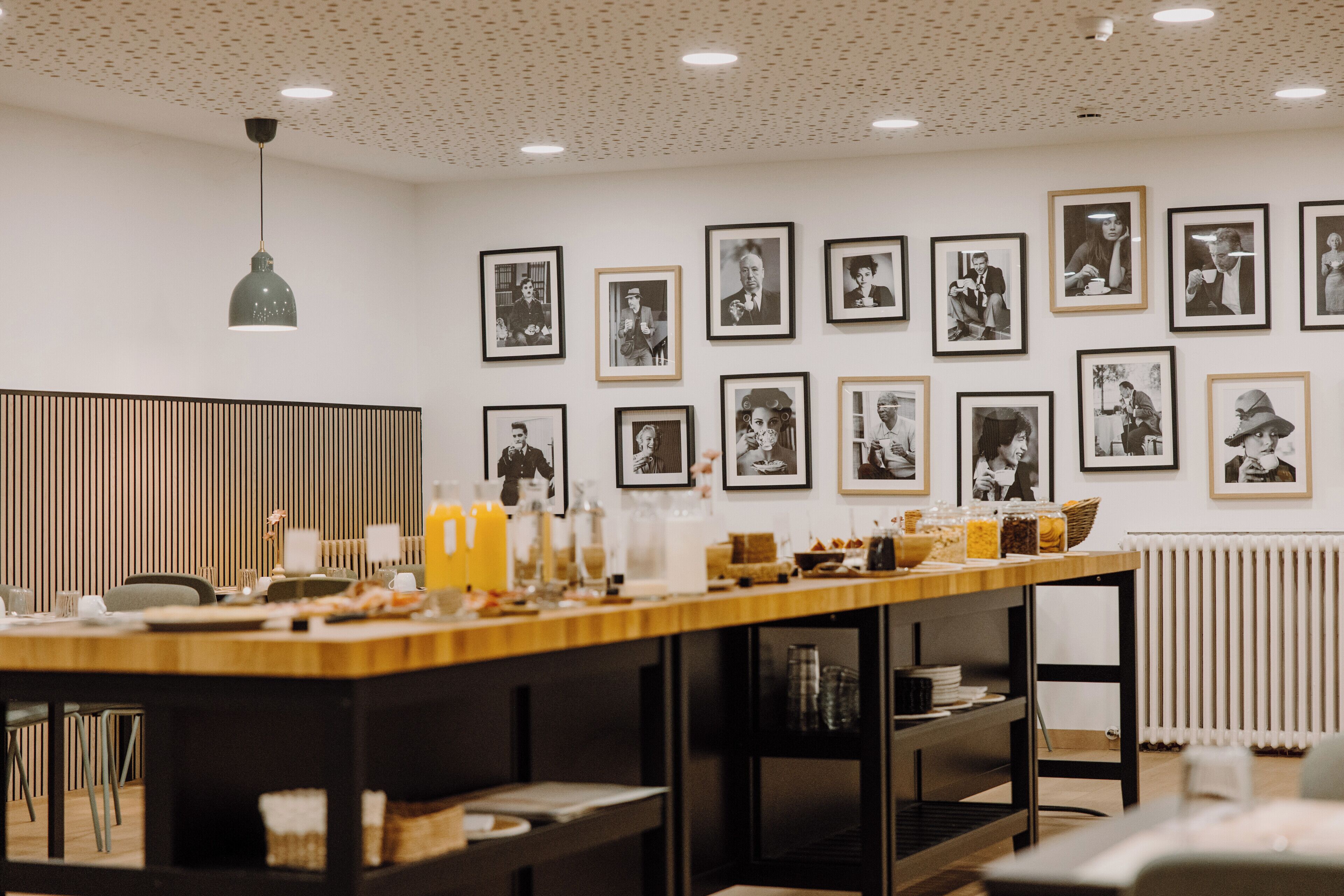 Un comedor moderno con una mesa larga, sillas y varios recipientes de comida y bebida.