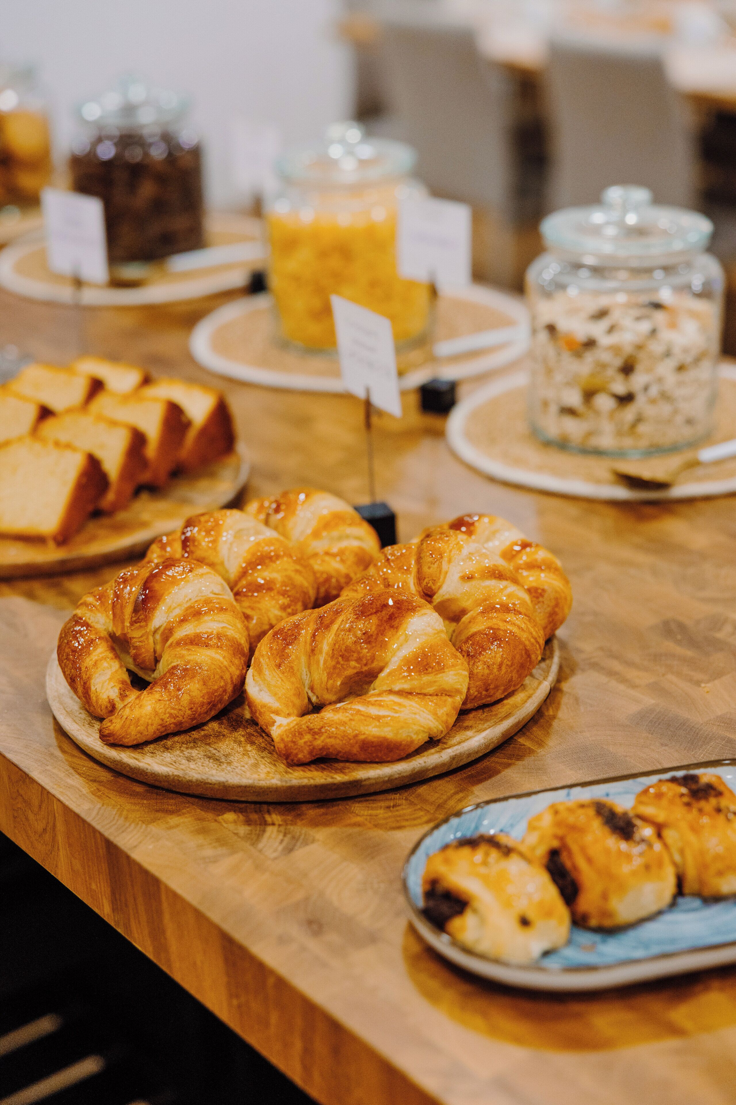 A table with various food items including pastries and bread.
