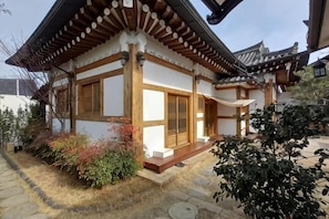 Ein traditionelles japanisches Gebäude mit einem Ziegeldach, Holzbalken und einem Kiesweg.