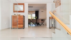 A modern interior with a wooden cabinet, dining area with chairs, and a staircase. - Villa Anteo-Split by Villas Guide (Košute)