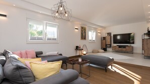 A modern living room with a grey sofa set, a coffee table, and a flat-screen TV mounted on the wall. - Villa Anteo-Split by Villas Guide (Košute)