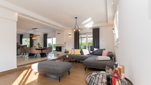 A spacious living area with a large sofa, a dining table, and a kitchen in the background. - Villa Anteo-Split by Villas Guide (Košute)