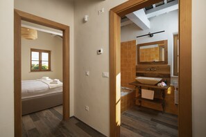 Une chambre d’hôtel avec un lit, une salle de bain comprenant un lavabo et un miroir, et une fenêtre donnant sur un paysage agréable.