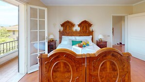 Une chambre à coucher avec un lit en bois, un balcon et une vue sur l’extérieur.