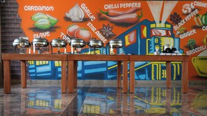 A buffet table with various food items and a colorful mural in the background. - Gandhada Goodu Retreat (Kanakapura)