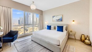 Een moderne hotelkamer met een groot bed, een bureau en uitzicht op de stad.