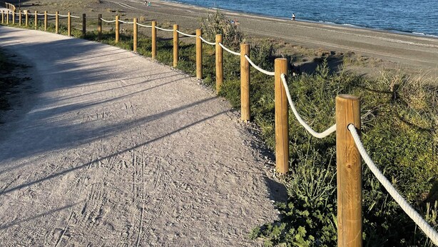 A coastal road with wooden guardrails and a clear view of the ocean and distant mountains. - Beach house in Manilva Beach, Costa del Sol, Costa del Sol, Spain (La Chullera)