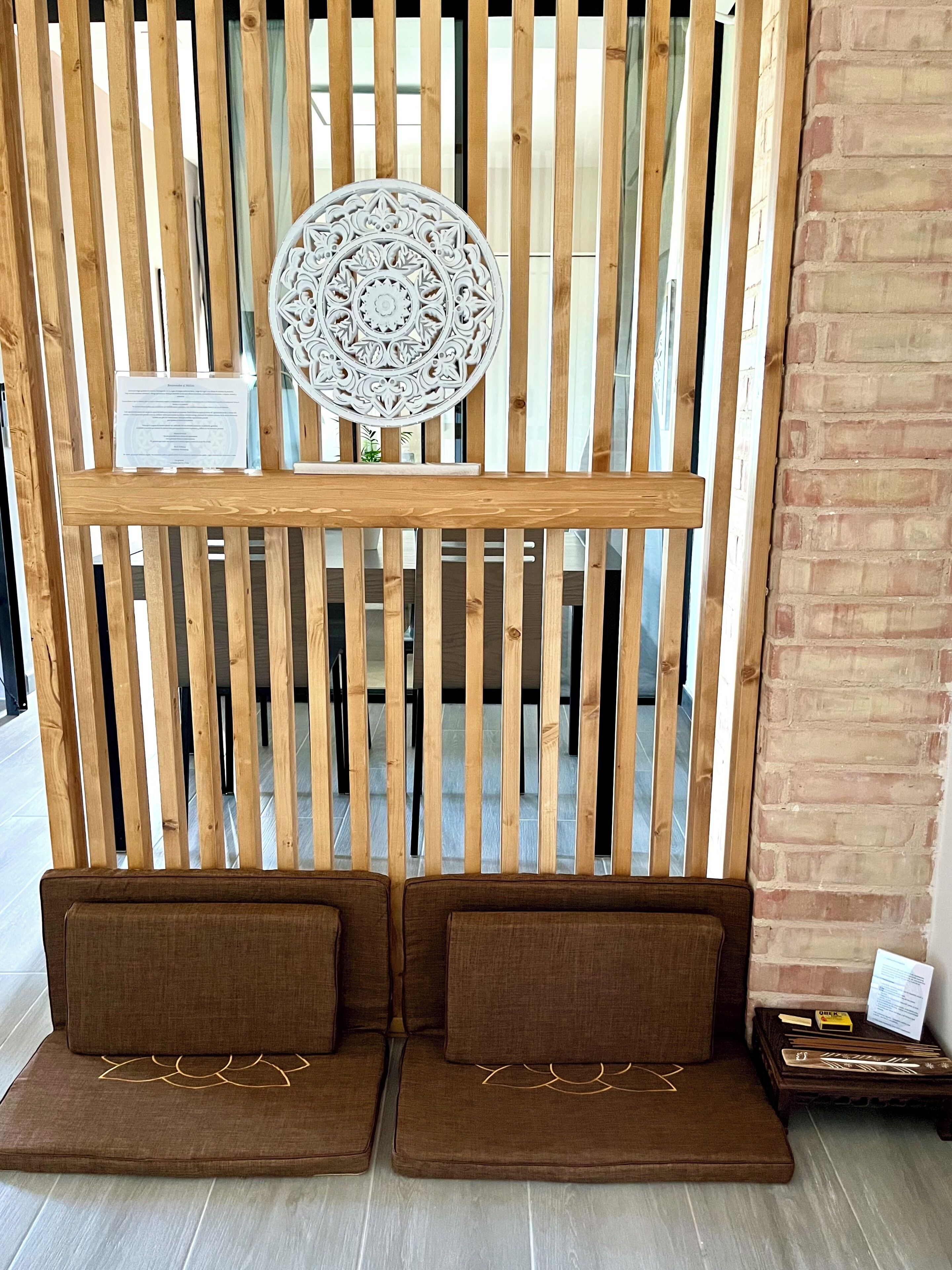 Une cloison en bois agrémentée d’un élément décoratif circulaire et une petite table avec un plateau.