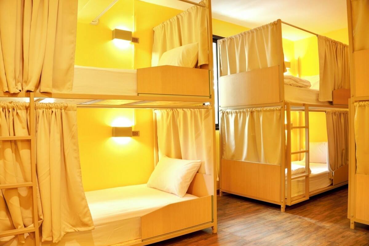 Habitación con literas, mesita de noche y luz empotrada en la pared.