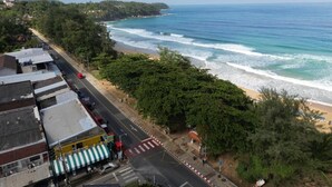 A coastal road with a beach and buildings.