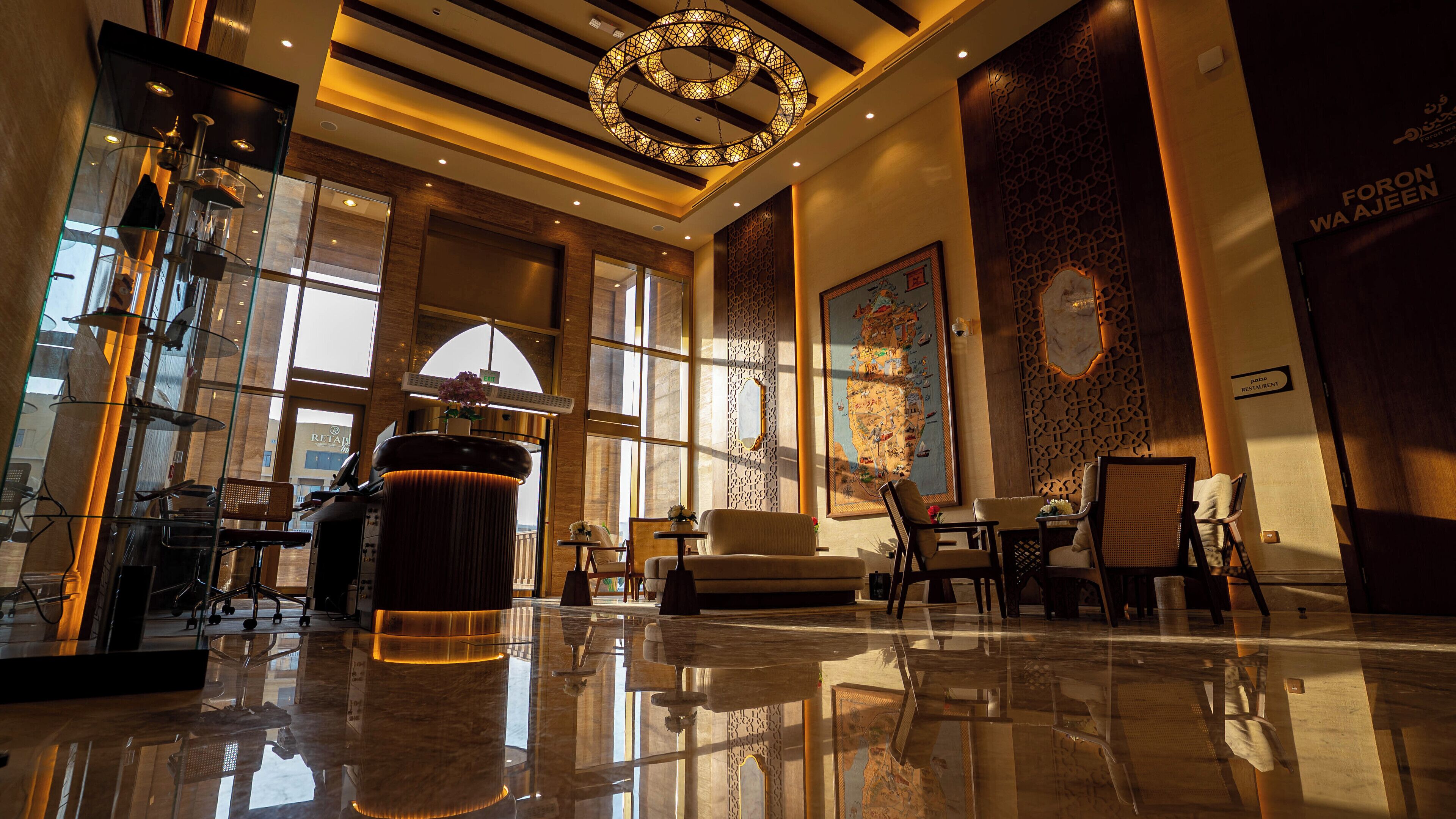 A modern lobby with a large chandelier, seating area, and a large map mural.