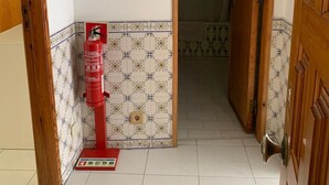A hallway with a fire extinguisher, a Wi-Fi sign, and a Complaints Book on the wall. - Vintage Chiado with Terrace (Lisboa)