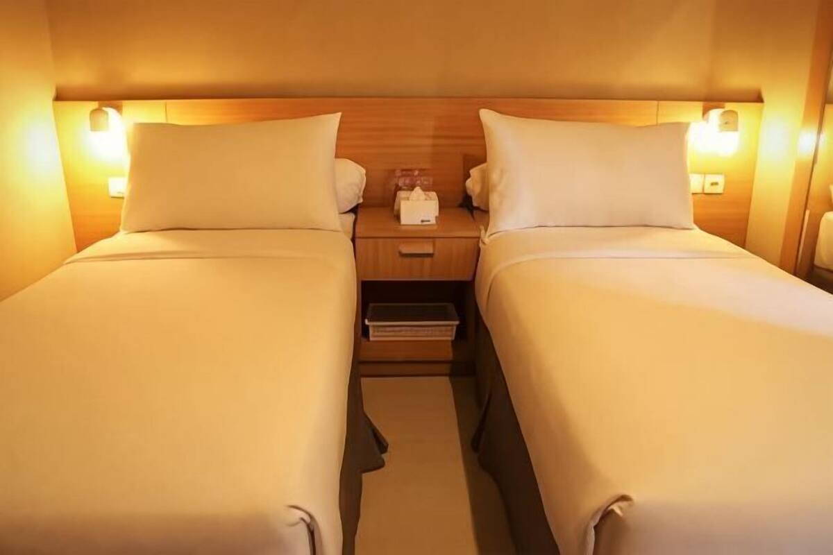 A double bed room with a wooden headboard, bedside tables, and a nightstand.