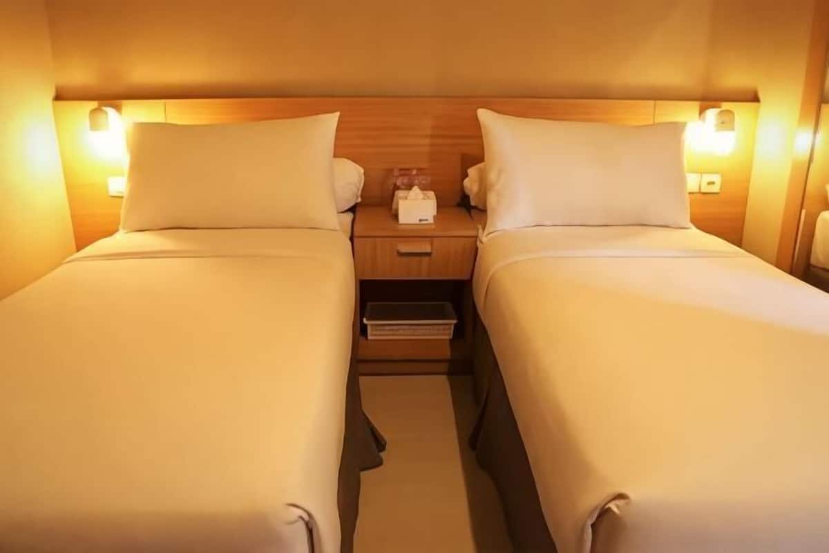 A double bed room with a wooden headboard, bedside tables, and a nightstand.
