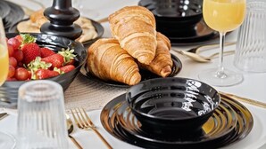 A breakfast setting with croissants, strawberries, and a glass of orange juice. - The Copper Nest 2BR City Centre (Leicester)