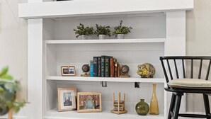 Uma estante branca com objetos decorativos e livros.