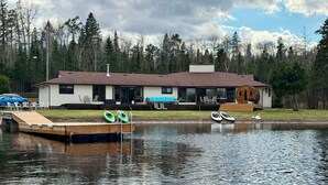 A lakeside cabin with a dock, kayaks, and a small boat. - 7-bed lakefront house with sauna, beach & boat launch — 15 min from Thunder Bay. (Thunder Bay)