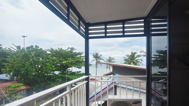 Un balcone con vista sul mare, un condizionatore Samsung e un pavimento piastrellato.