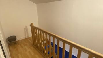 Un escalier en bois avec un mur bleu en haut.