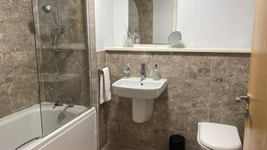 A bathroom with a glass-enclosed shower, a white sink, and a toilet. - Apartment - Sleeps 4, Pets Allowed & Parking (Salford)