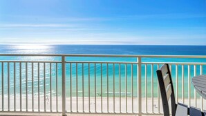 A balcony with a view of the ocean and beach.