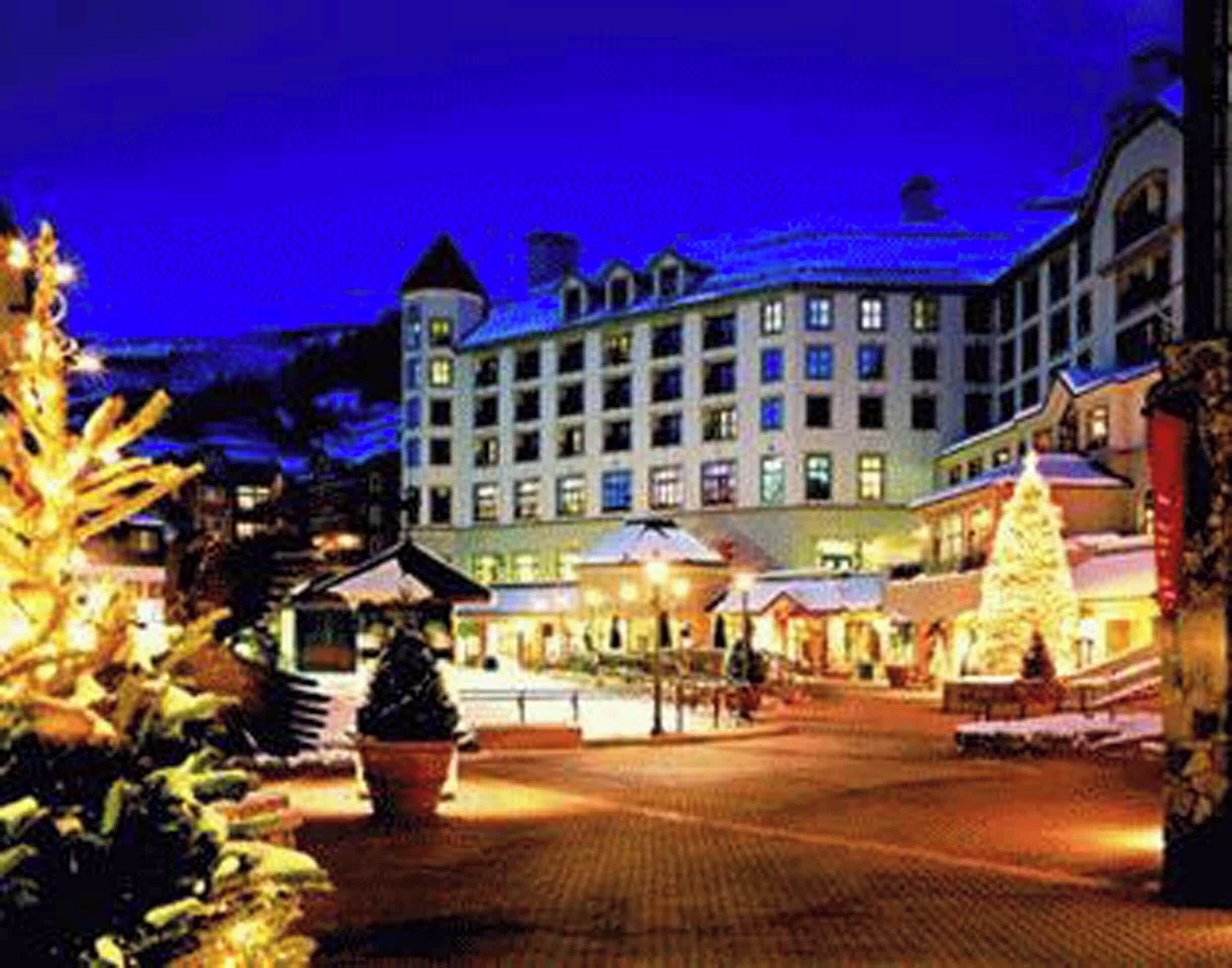 A hotel with a central courtyard, multiple floors, and a prominent Christmas tree.