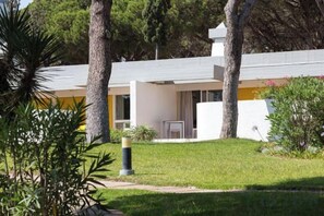 A modern building with a flat roof, surrounded by greenery and trees. - Apartamentos Turisticos Pinhal Da Marina (Vilamoura)