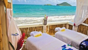 A beachside room with two beds, a view of the ocean, and a wooden deck. - KAE2 (Michamvi)