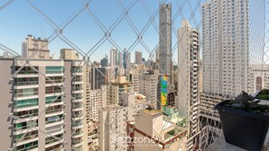 A high-rise building with multiple balconies and a clear view of the cityscape.