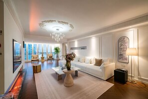 A spacious living room with a white sofa, a coffee table with a vase, and a chandelier. - Book and Bed-People's Square (Shanghai)