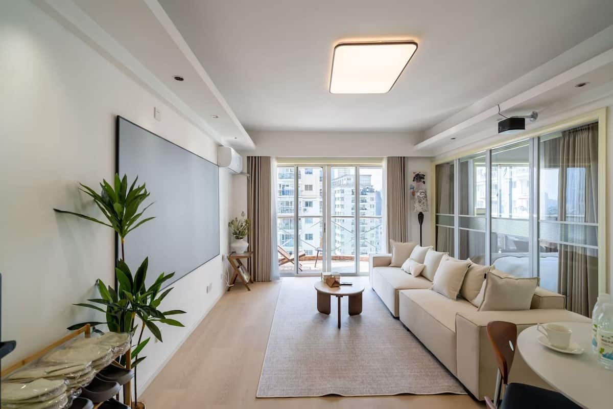 A modern living room with a sofa, a coffee table, and a large window.