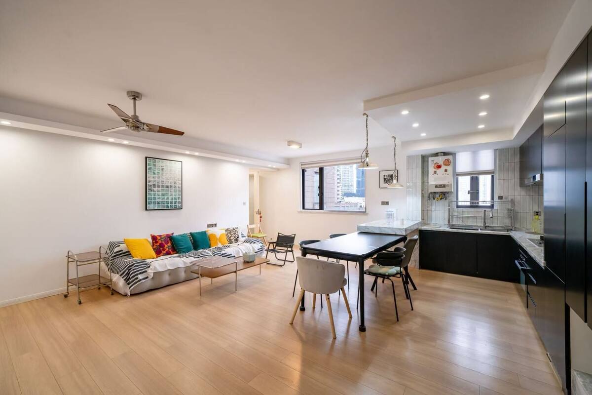 A modern apartment with a dining area, kitchen, and living room.