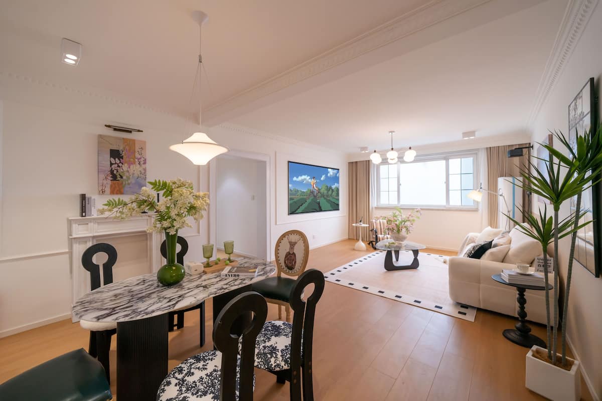 A spacious living area with a dining table, chairs, a sofa, and a coffee table.