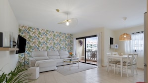 A modern living room with a sofa, coffee table, and dining area. - Luxury Penthouse Plaza Apartment with Mountain View, Private Terrace, and Wi-Fi (Playa San Juan)