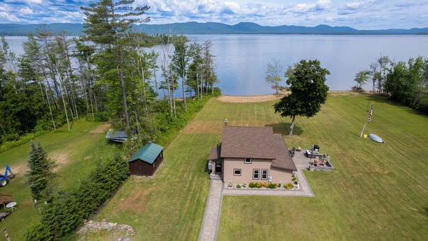 A house with a lawn, a dock, and a view of a lake.