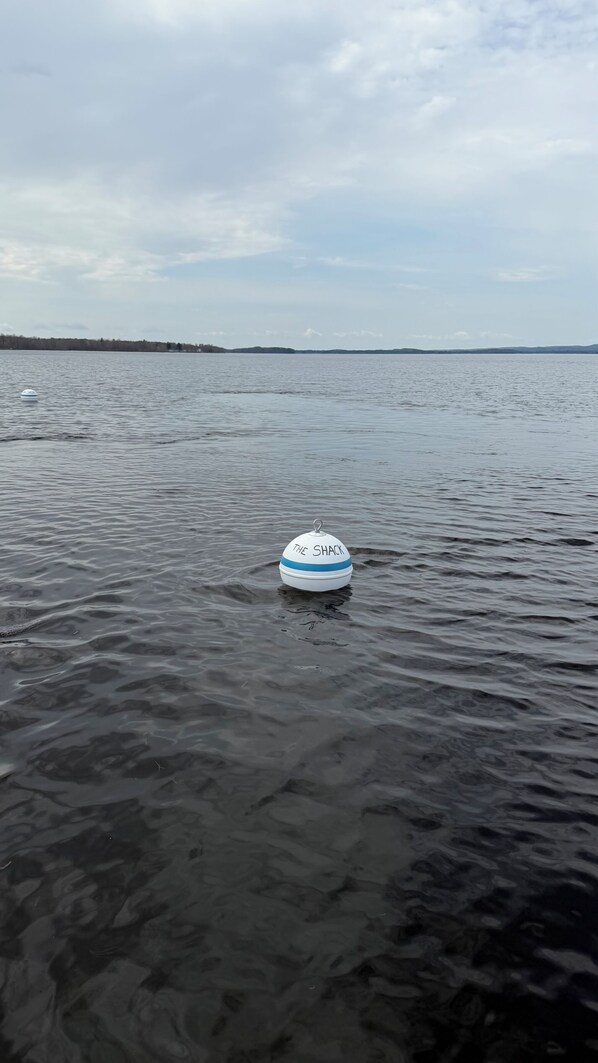 A buoy with 'THE SHACK' written on it floating in calm water. - Spacious 5-bedroom, 2-bathroom house in charming Broadalbin directly on the lake (Broadalbin)