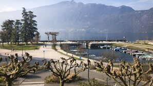 A coastal area with a marina, a pedestrian path, and mountains in the background. - Les Flots Harmonieux (30m² lake view) (Aix-les-Bains)