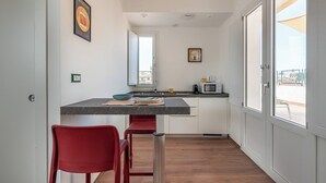 Una cucina compatta con zona pranzo, una finestra e una porta che dà su un'area esterna.