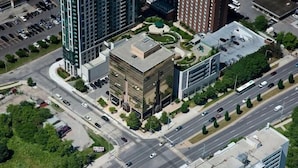 An aerial view of a modern building complex with multiple high-rise structures, a central courtyard, and a parking area. - Rook Hotel   (Mississauga)