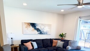 A modern living room with a sectional sofa, a grey armchair, and a coffee table. - Family-friendly 4 bd with sparkling free heated pool, , games. ASU close (Tempe)